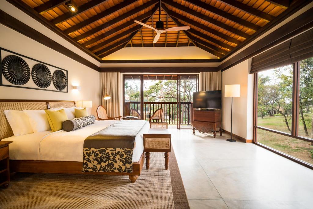 a bedroom with a large bed and a television in it at Anantara Peace Haven Tangalle Resort in Tangalle