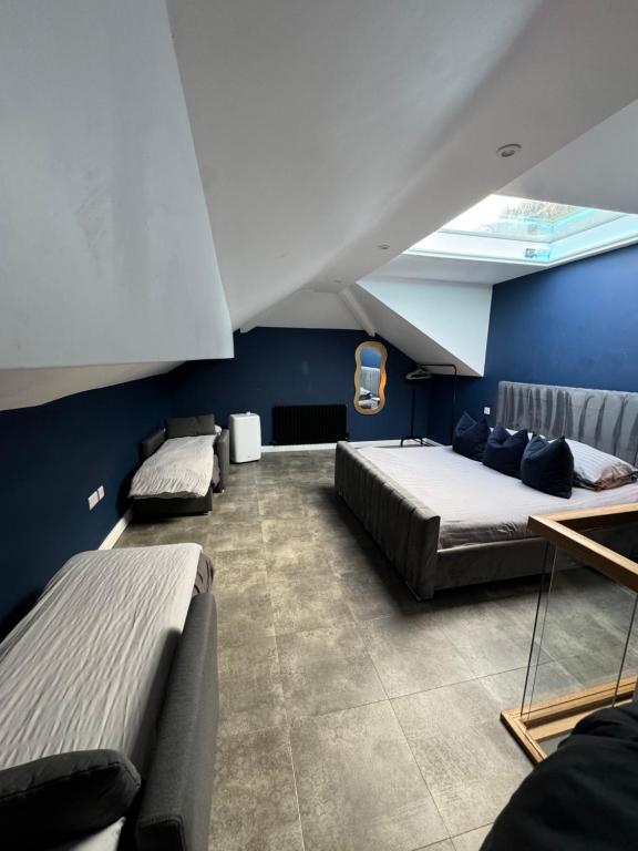 a bedroom with two beds and a blue wall at terfyn hall holiday apartment 3 stargazer in Prestatyn