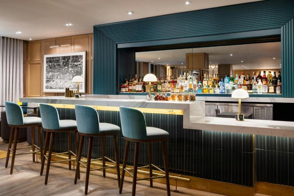 a bar with blue bar stools and a mirror at Residence Inn by Marriott New York Downtown Manhattan/World Trade Center Area in New York