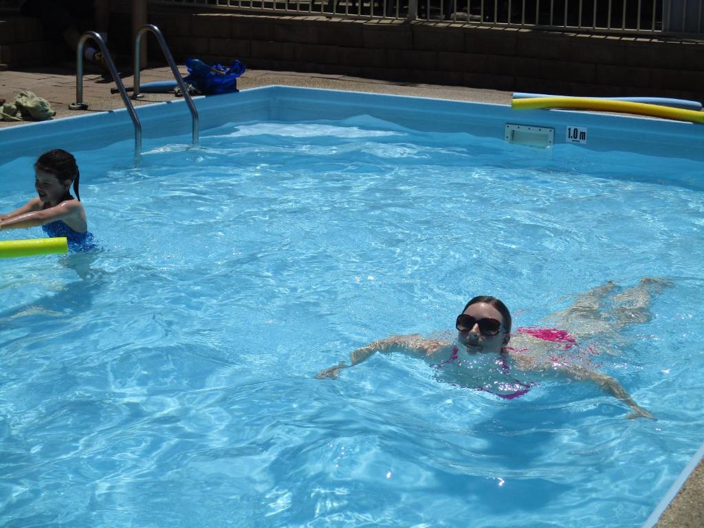 una mujer y un niño en una piscina en Anchorbell Holiday Apartments, en Merimbula