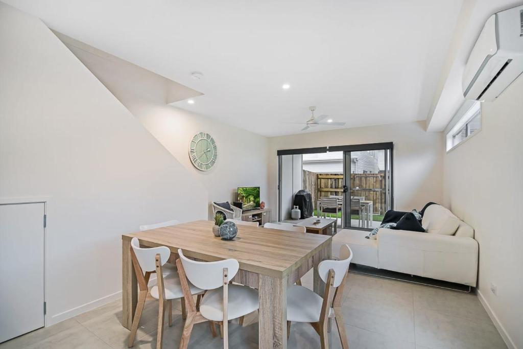 Una cocina y un comedor con mesa y sillas. en Suncoast Beach Drive Townhouses, en Yaroomba