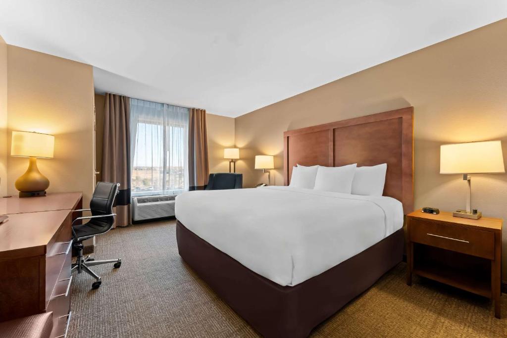 a hotel room with a large bed and a desk at Comfort Inn & Suites Avera Southwest in Sioux Falls