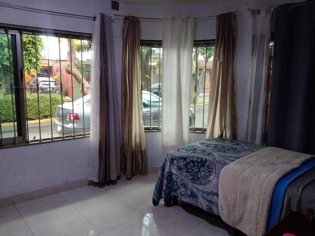 a bedroom with a bed and large windows at Pico Orizaba country in Orizaba