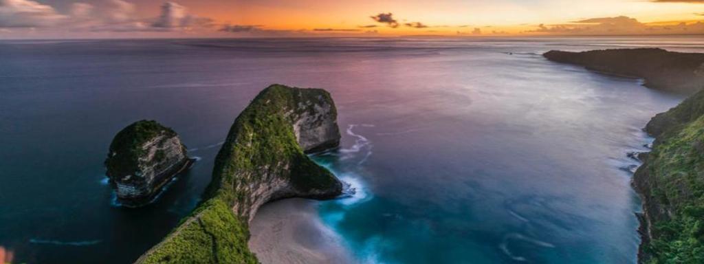 una vista aérea de las rocas del océano al atardecer en One Day West Nusa Penida Tour by Funs Bali Island, en Sanur
