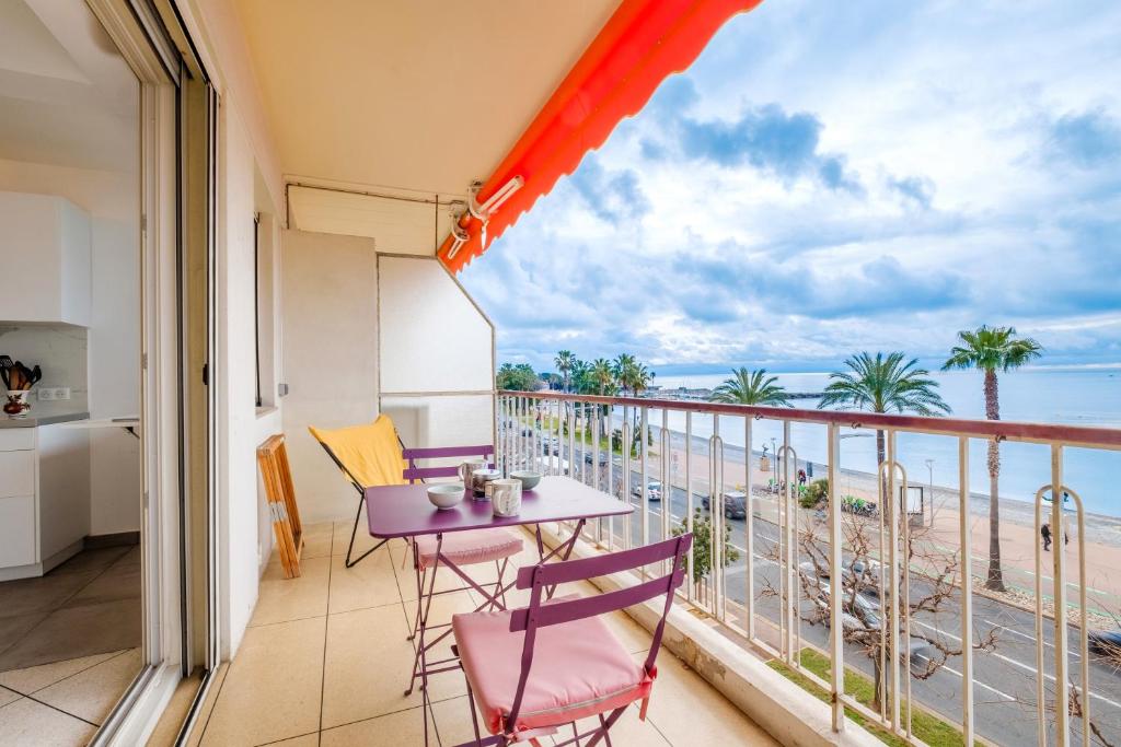 a balcony with a table and chairs and a view of the ocean at Angelina 2 pièces vue mer - Bej001 in Cros-de-Cagnes