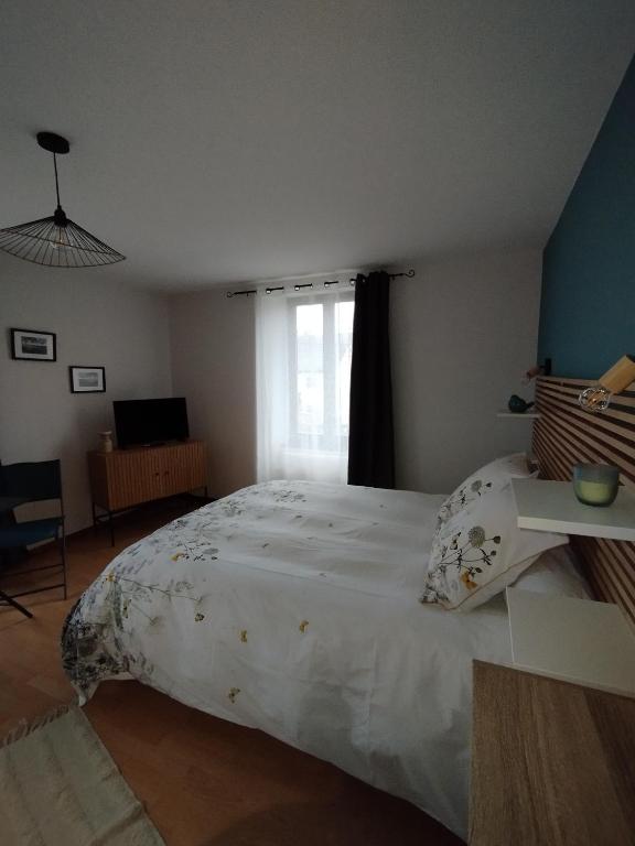 une chambre avec un grand lit blanc et une fenêtre dans l'établissement Chambre d'hôte Nature Domaine du Bagnerot, à La Chapelle-aux-Bois