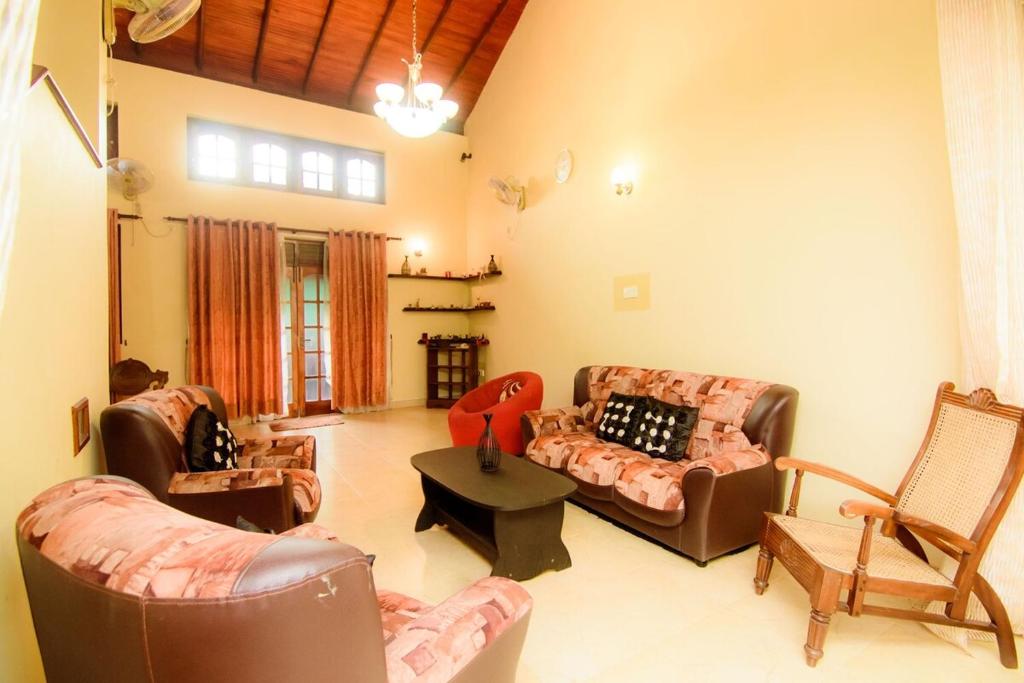 a living room with two couches and a table at The House Dewata in Galle