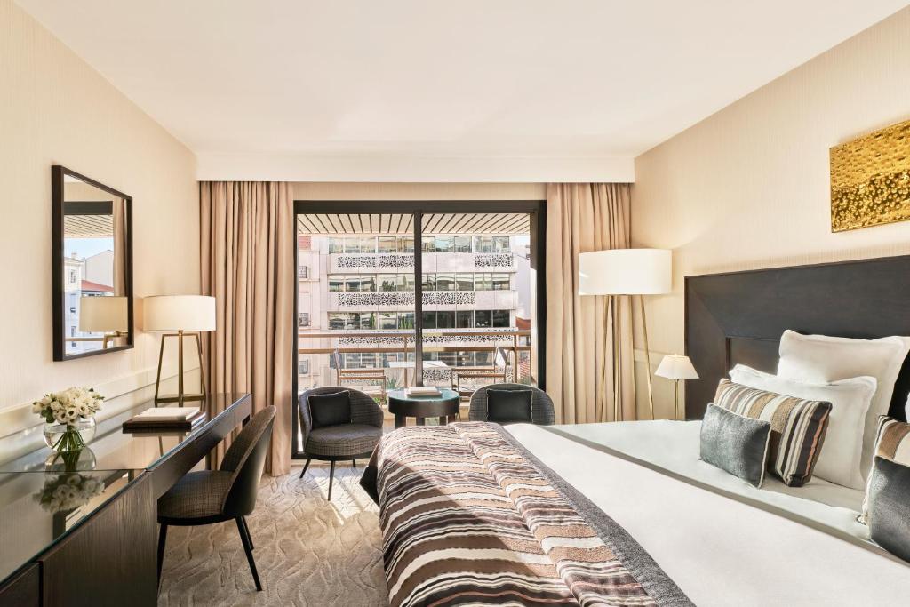a hotel room with a large bed and a window at Hôtel Barrière Le Gray d'Albion in Cannes