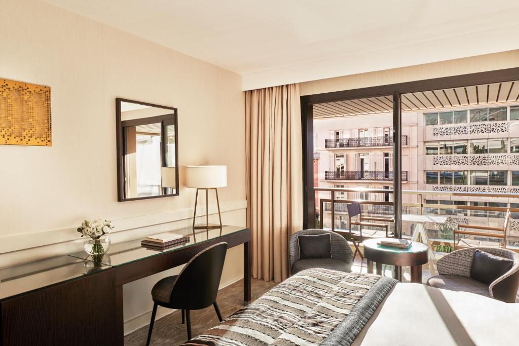 a hotel room with a bed and a desk at Hôtel Barrière Le Gray d'Albion in Cannes