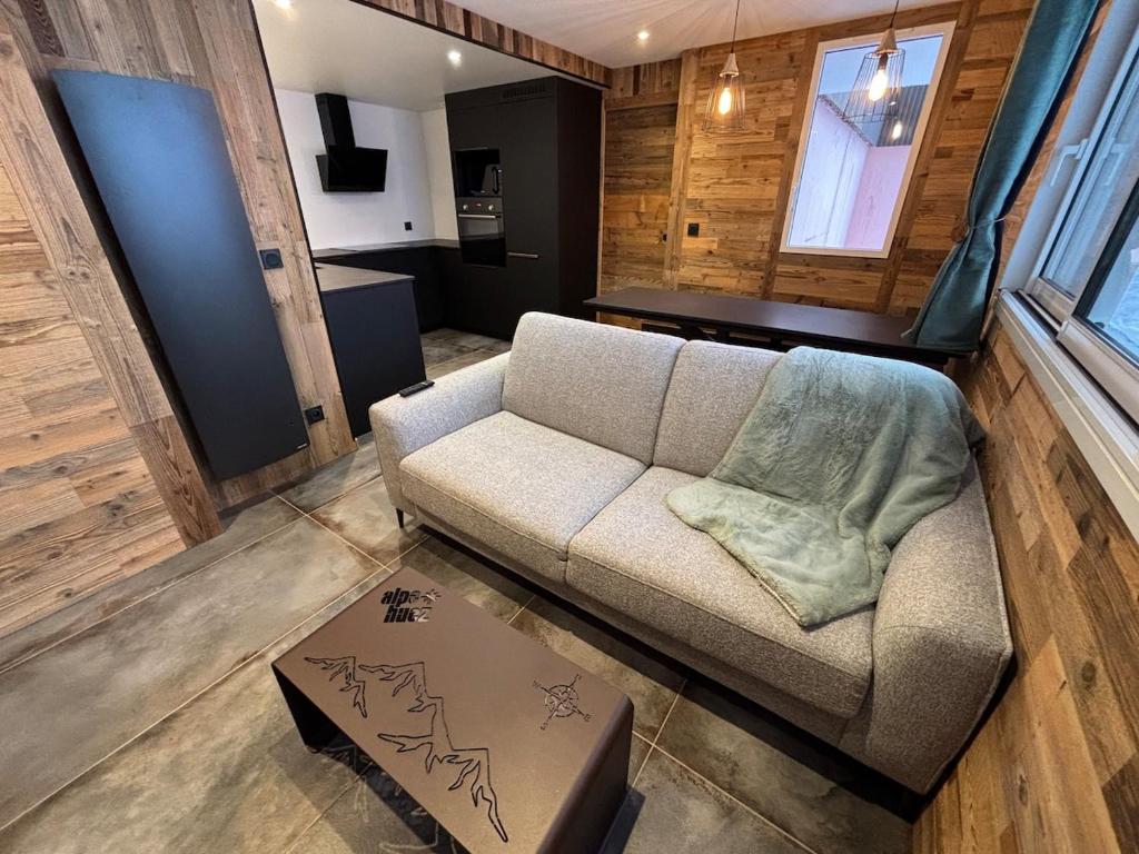 un salon avec un canapé et une table dans l'établissement Le Refuge des Mômes, à Huez