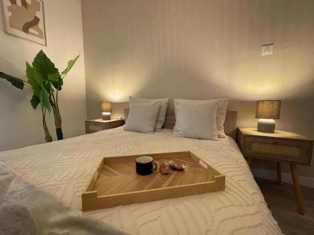 un vassoio sopra un letto con una tazza sopra di L 'Écrin Ivoire - Comfort and Productivity -Terrasse a Brive-la-Gaillarde