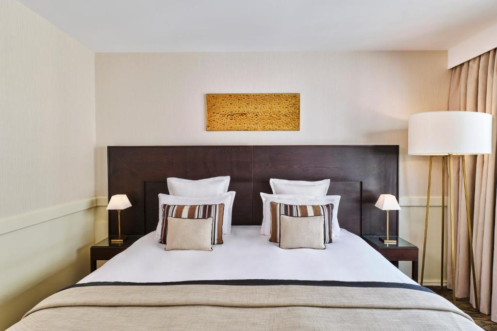 a bedroom with a large white bed with pillows at Hôtel Barrière Le Gray d'Albion in Cannes