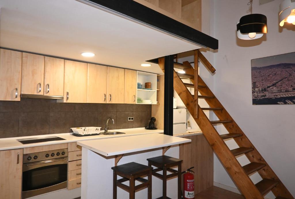 een keuken met een trap naar een loft bij Homenfun Barcelona Vallcarca in Barcelona