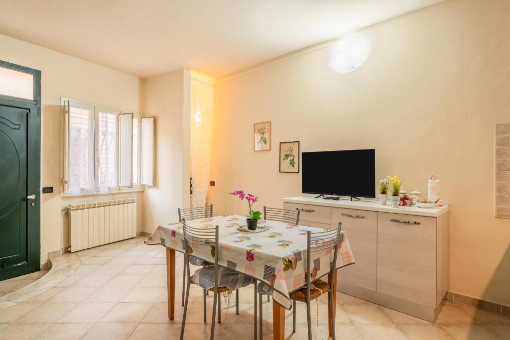 a dining room with a table and a tv at Casa Angeli - By The River in Lucca