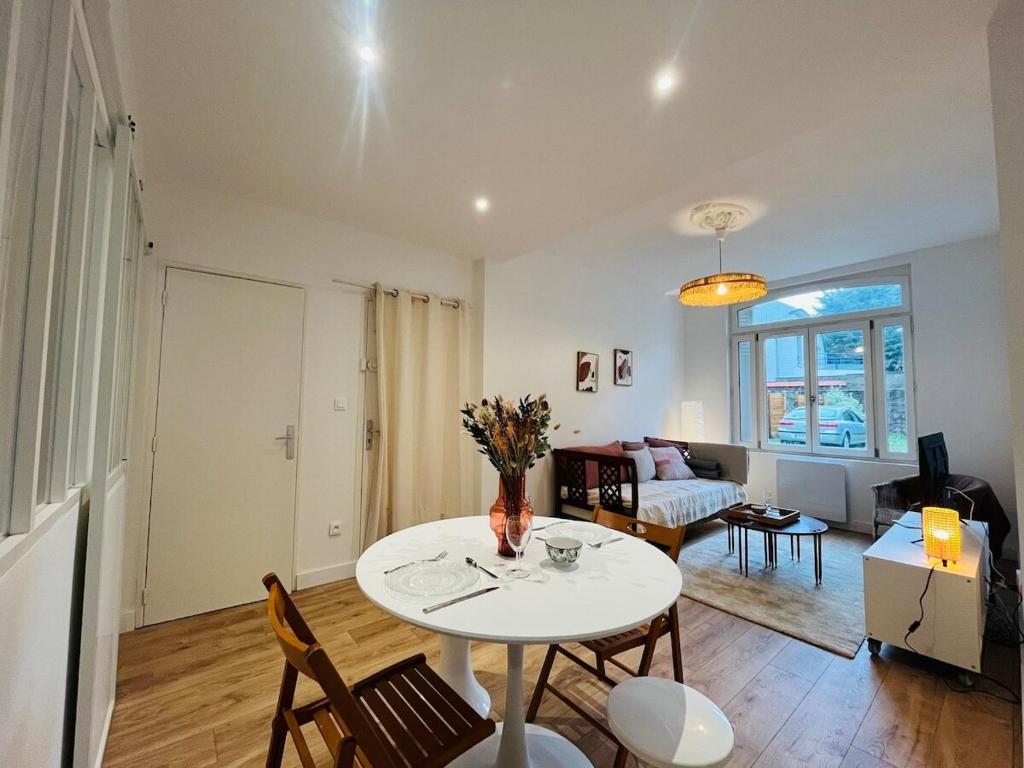 un salon avec une table et des chaises blanches dans l'établissement Casa Predali, à Angers