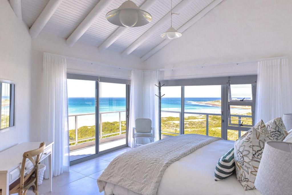 a bedroom with a bed and a view of the ocean at Simply Stunning but smaller in Cape St Francis