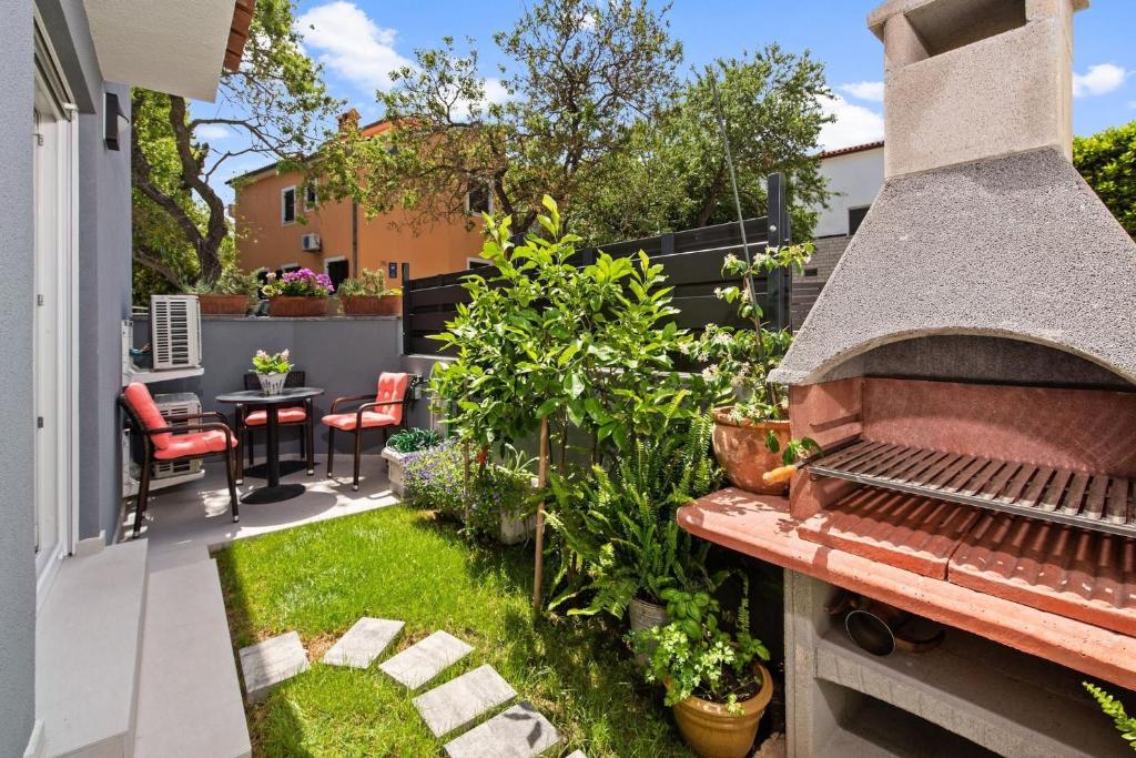 a small garden with a barbecue on a patio at Holiday Home Sea in Premantura