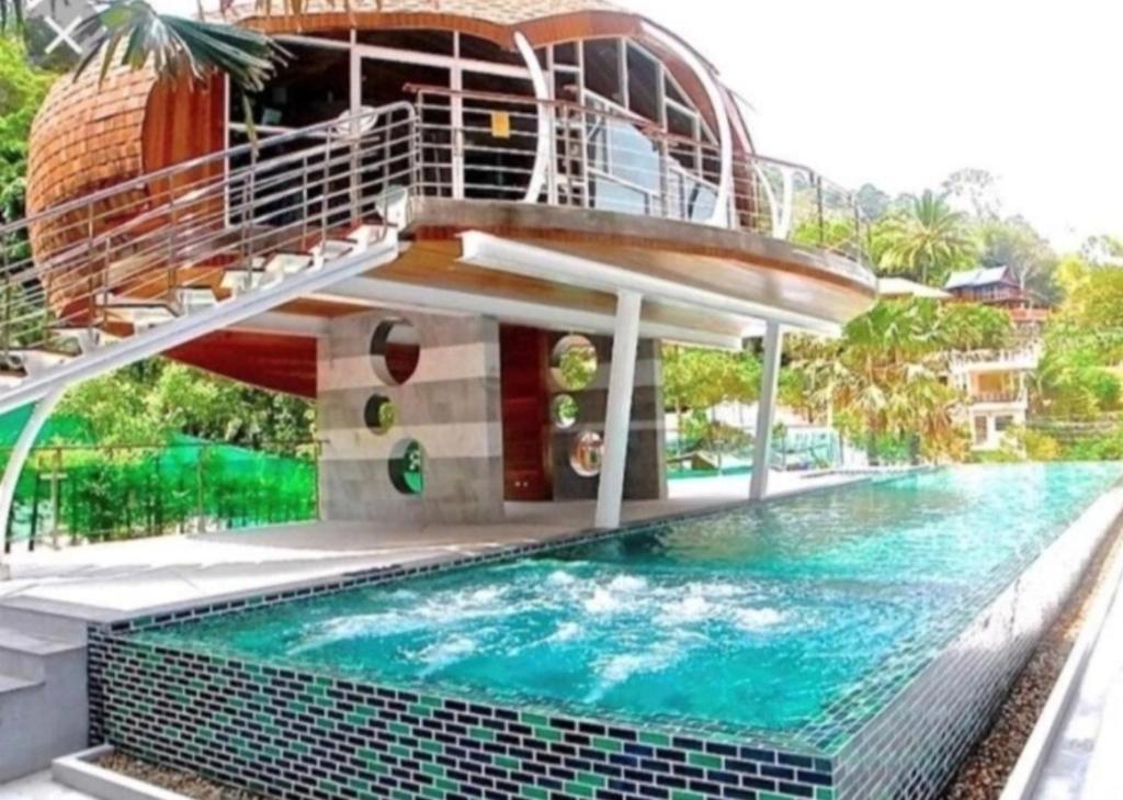 a house with a swimming pool with a staircase above it at Emerald Terrace Resort 2 bedrooms Panoramic Ocean View Top Floor in Patong Beach