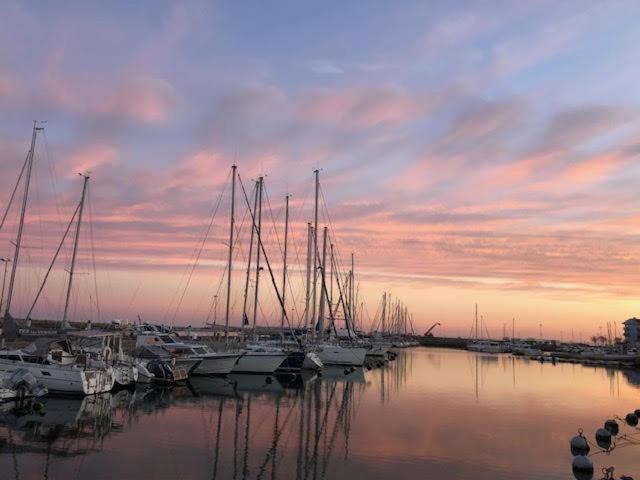 un groupe de bateaux amarrés dans une marina au coucher du soleil dans l'établissement Appartement 4 personnes Valras Plage, à Valras-Plage