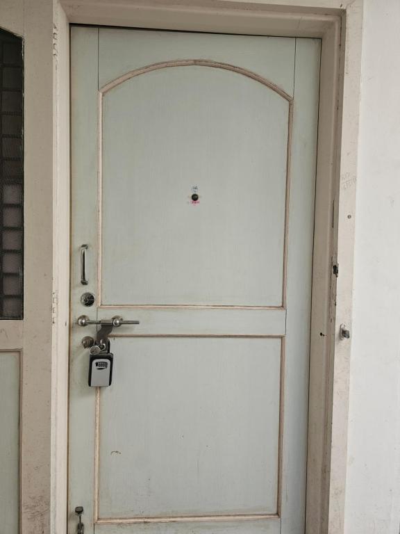 a white door with a handle on a building at Laxmi Happy Home in Pune in Pune
