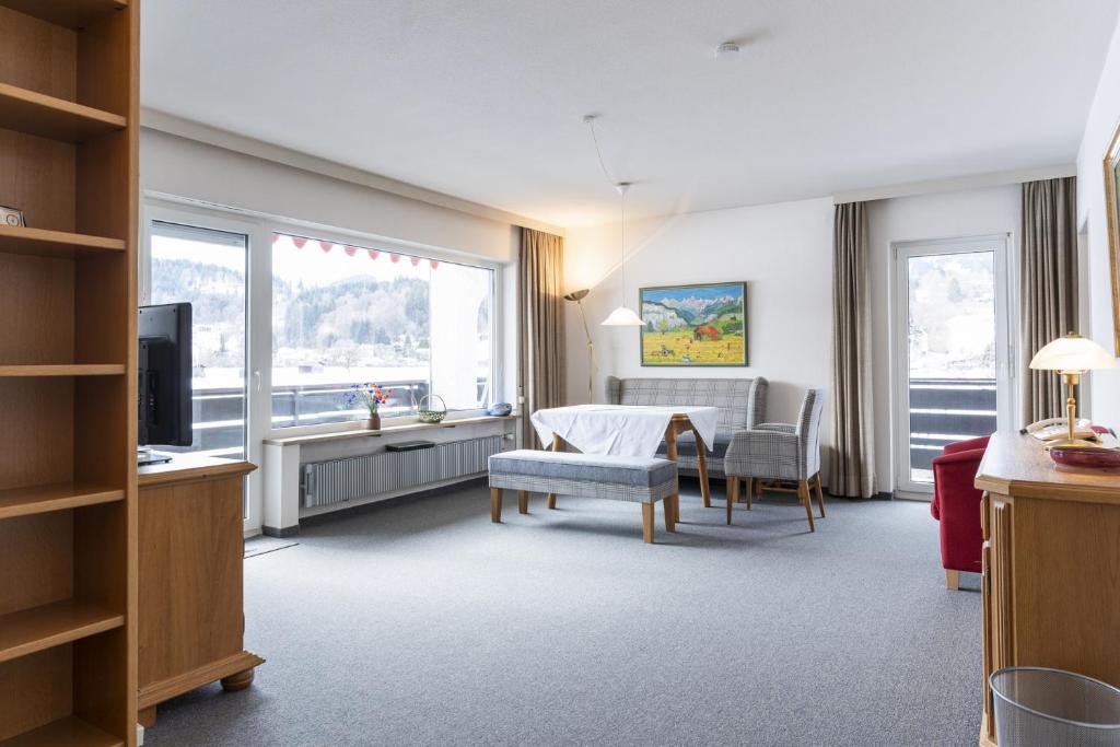 een woonkamer met een tafel, stoelen en een televisie bij Ferienwohnung Richter in Oberstdorf