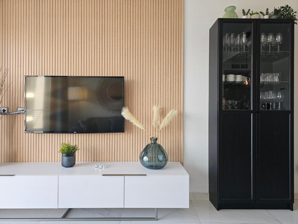 Televízia a/alebo spoločenská miestnosť v ubytovaní Infinity View Penthouses by NRAS