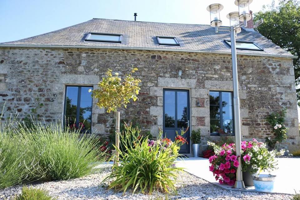 une maison en pierre avec des fenêtres et un lampadaire dans l'établissement La petite vallée, à Saint-Calais-du-Désert
