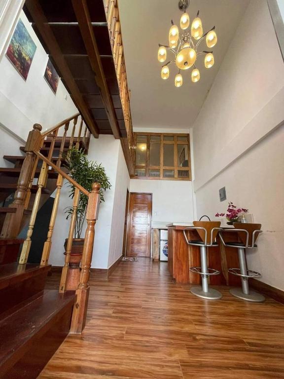 a living room with a staircase and a chandelier at Appleton Liitle Paradise Beach Resort & Restaurant Seaside Villa in Real
