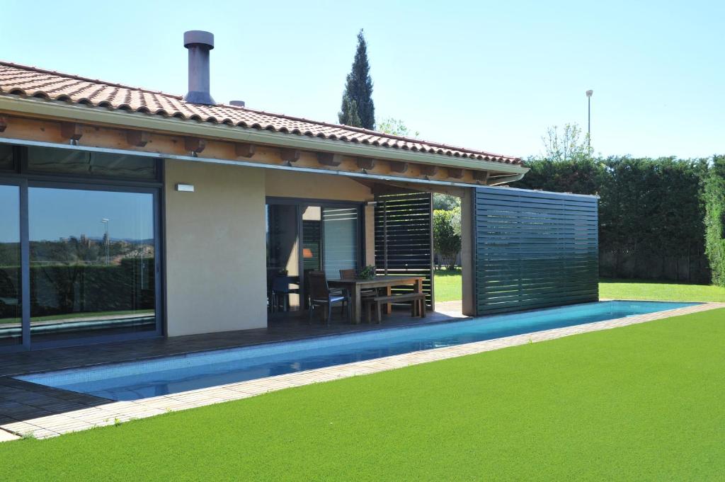 una casa con piscina e un patio con un tavolo di Casa LLEVADORA - Villa amb piscina privada a PALS a Pals