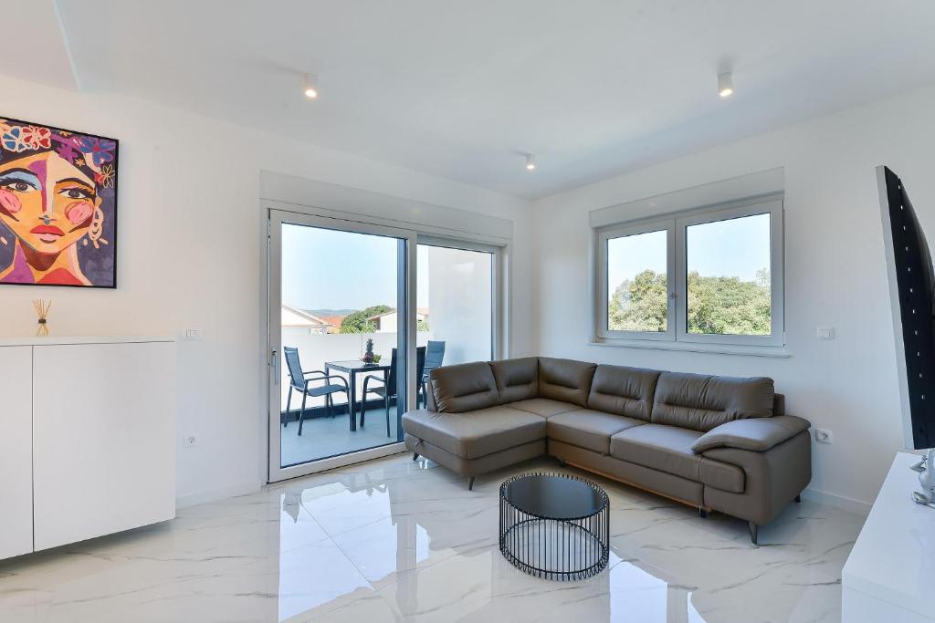 een woonkamer met een bank en een tafel bij Villa DIV with pool in Bibinje
