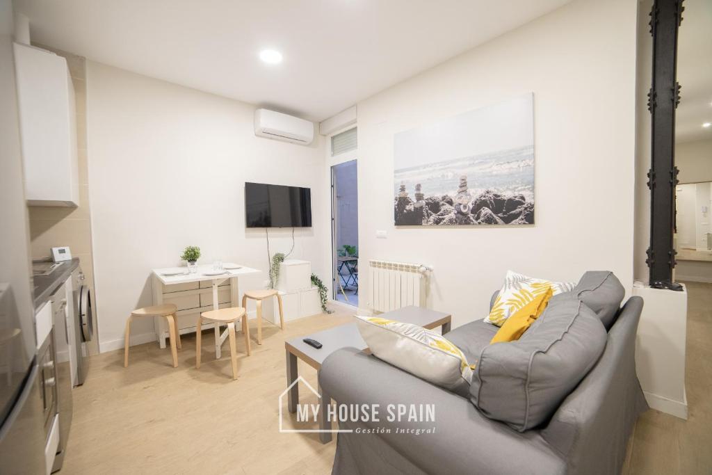salon z kanapą i stołem w obiekcie MyHouseSpain - Acogedor piso con patio en Chamberi w Madrycie