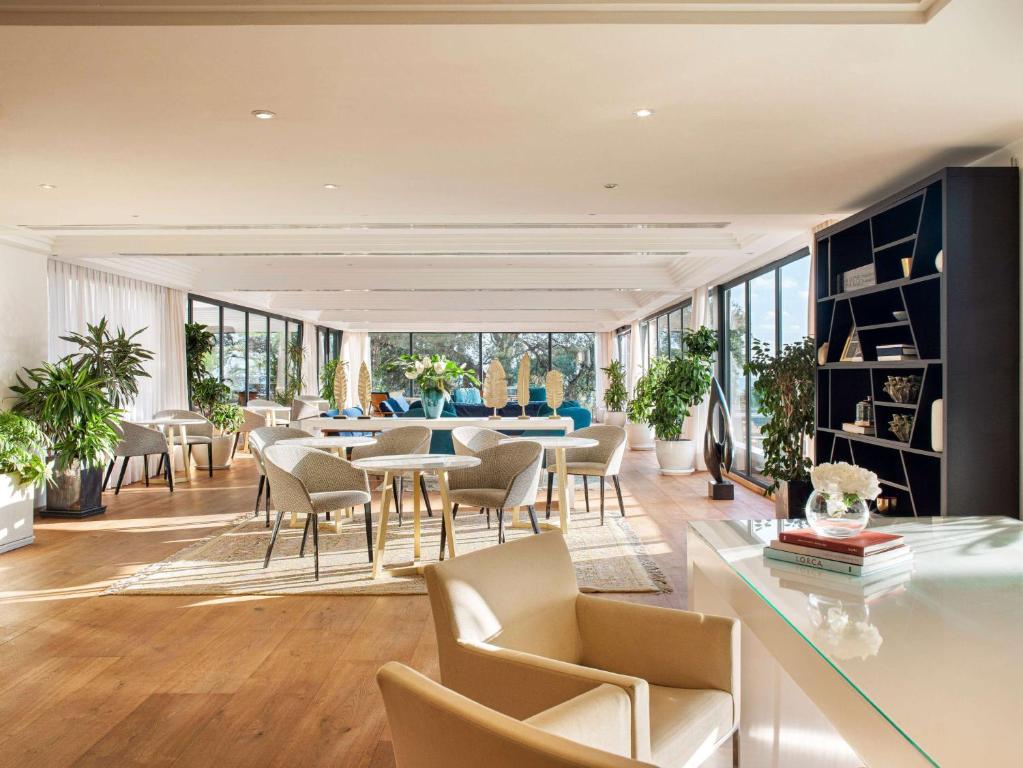 a living room with a table and chairs at Hotel Don Pepe Gran Meliá in Marbella
