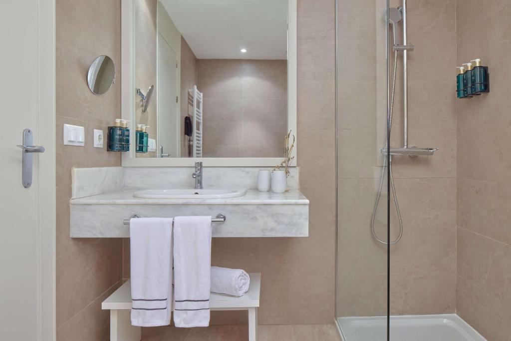 a bathroom with a sink and a shower at Meliá Cala Galdana in Cala Galdana