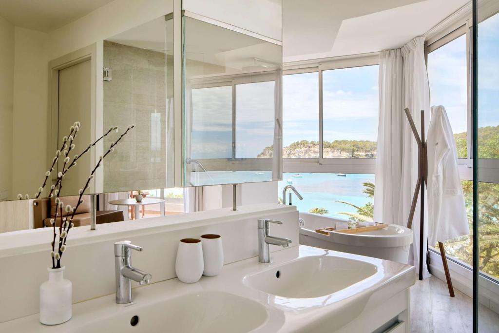 a bathroom with two sinks and a large mirror at Meliá Cala Galdana in Cala Galdana