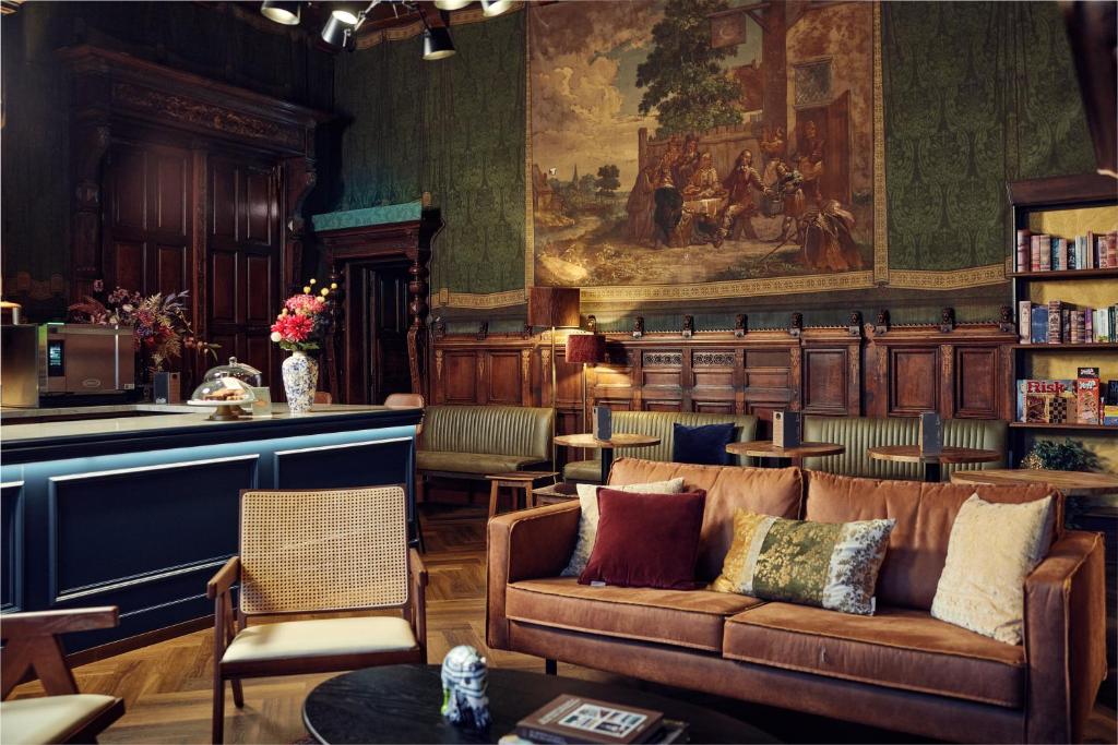 ein Wohnzimmer mit einer Couch und einem Gemälde an der Wand in der Unterkunft The Elephant Hostel in Amsterdam