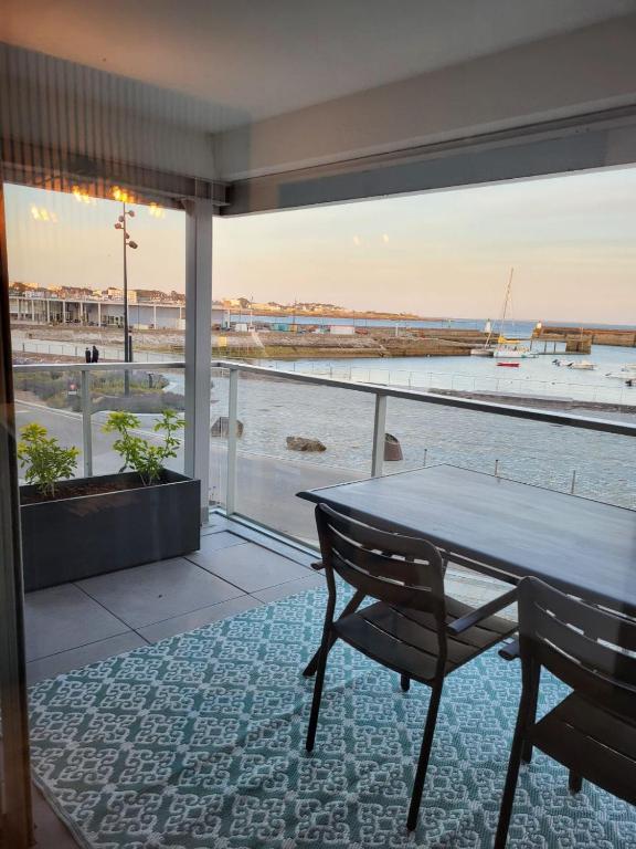une table et des chaises dans une pièce avec vue sur l'océan dans l'établissement Grande studio vue mer proche embarcadère, à Quiberon