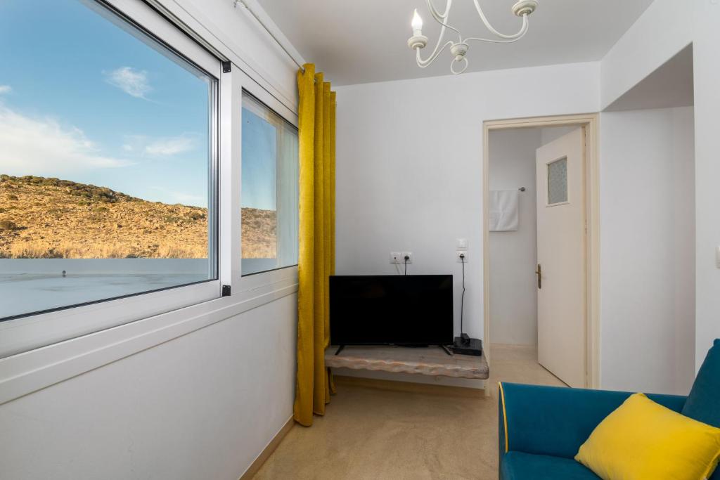 a living room with a window and a television at Tranquille House in Provatas