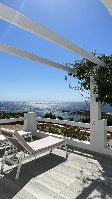 a lounge chair on a deck with a view of the ocean at Silene Villas in Amoopi