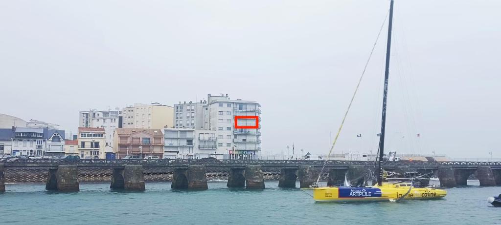 un bateau jaune dans l'eau à côté d'un pont dans l'établissement Appartement vue sur chenal - parking, à Les Sables-dʼOlonne
