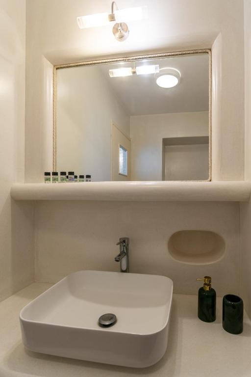 a bathroom with a white sink and a mirror at Tranquille House in Provatas