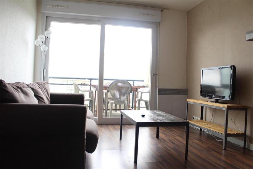 un salon avec un canapé, une télévision et une table dans l'établissement Appt 2 pièces LA ROCHELLE - LR380-027, à La Rochelle