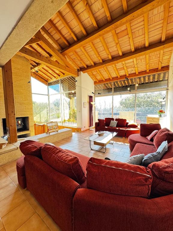 un grand salon avec des canapés rouges et une cheminée dans l'établissement LE SIG - Piscine - Jardin - 6 Chambres, à Piolenc