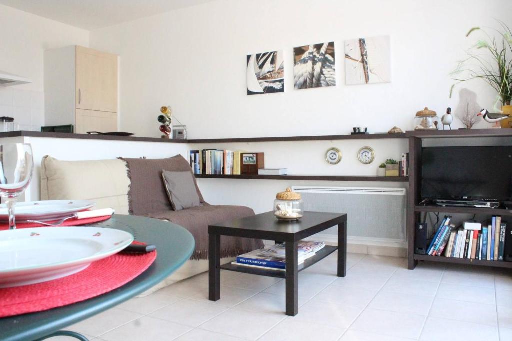 un salon avec un canapé et une table dans l'établissement Appartement 2 pièces Chatelaillon - CL100-007, à Châtelaillon-Plage