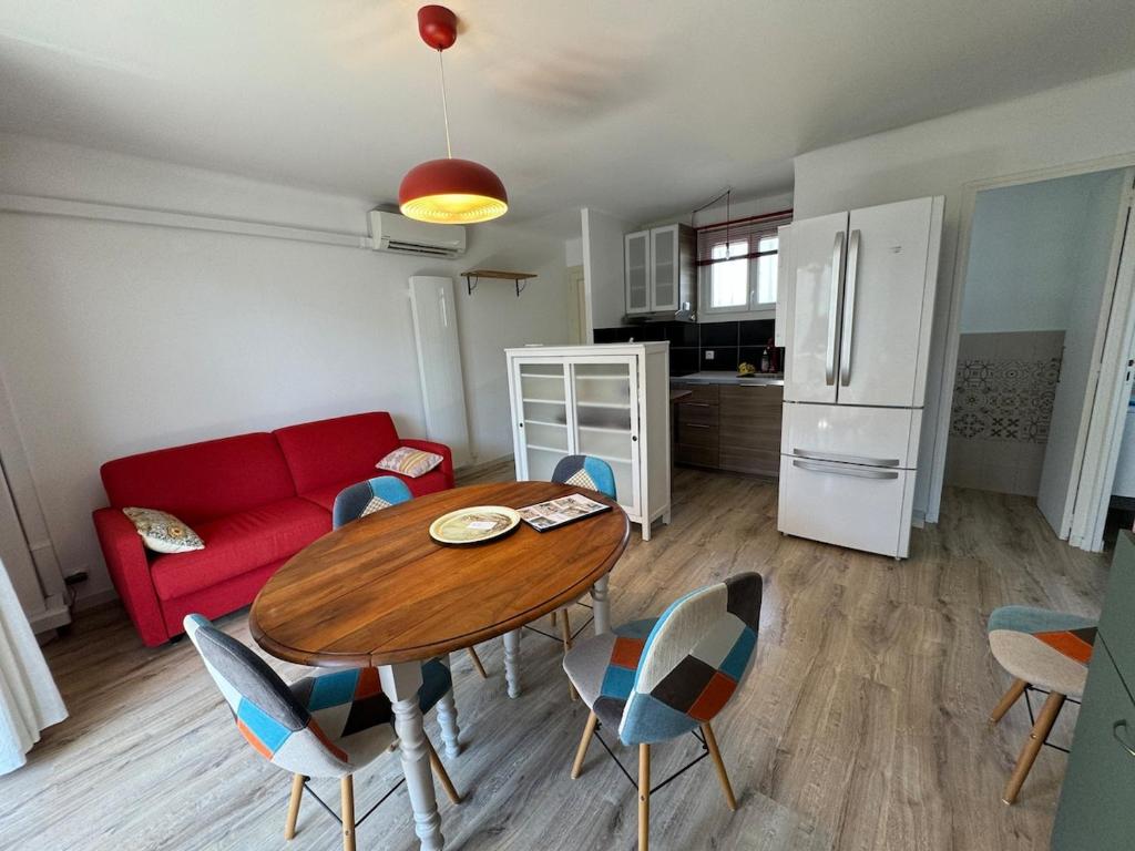un salon avec une table et un canapé rouge dans l'établissement T2-4 pers-terrasse - 200m mer, à Six-Fours-les-Plages