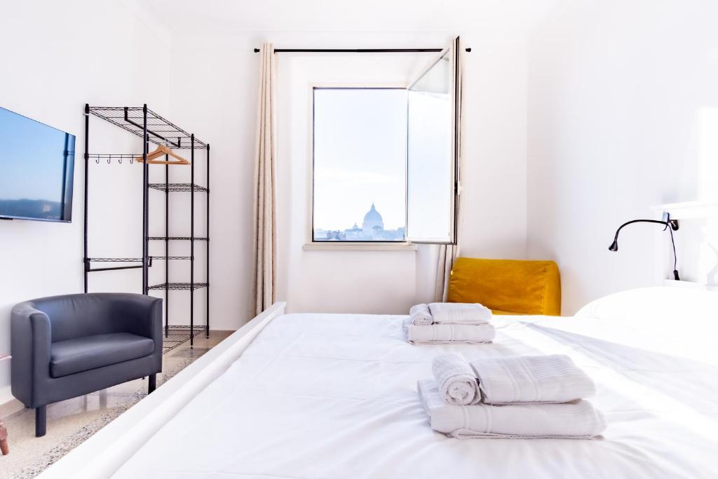 ein weißes Schlafzimmer mit einem Bett und einem Stuhl in der Unterkunft Elegantis La Dolce Vista Apartment with private terrace and fantastic View in Rom