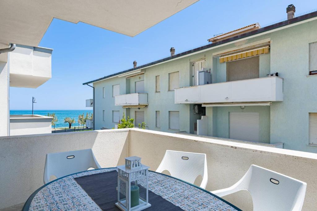 a balcony with a table and chairs and a view of the ocean at Appartamento Venere - YourPlace Abruzzo in Fossacesia