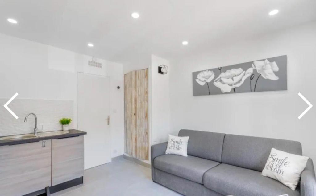 - un salon avec un canapé et un lavabo dans l'établissement La petite Madrague, aux Lecques