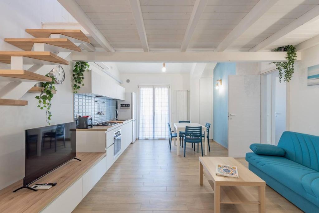 a living room with a blue couch and a kitchen at Blu Mare - YourPlace Abruzzo in Marina San Vito