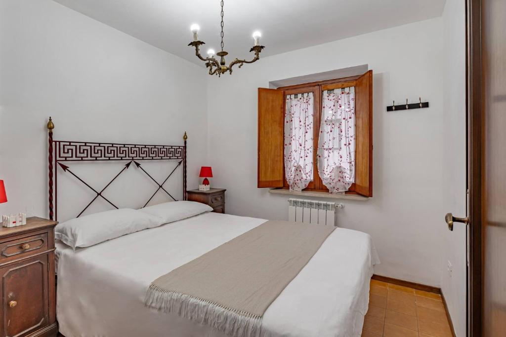 een slaapkamer met een groot wit bed en een kroonluchter bij Via Roma 44 - YourPlace Abruzzo in Roccaraso