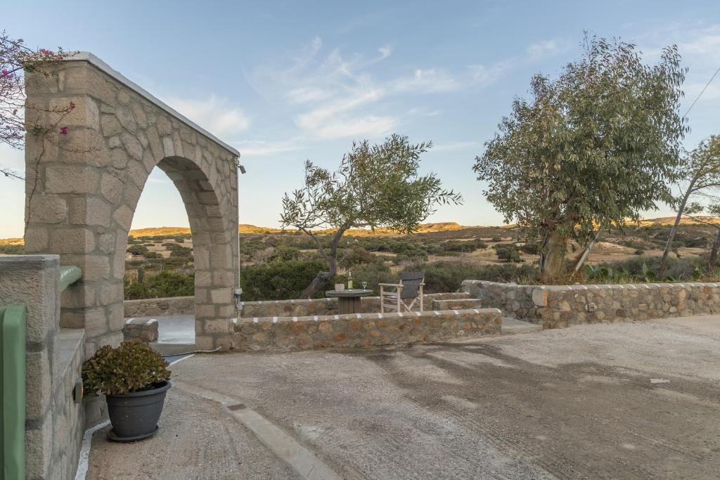 a stone building with an arch in a field at Tranquille House in Provatas